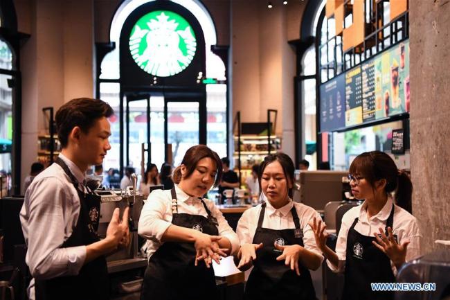 Staff members practice sign language in a Starbucks coffee store in Guangzhou, south of China's Guangdong Province, May 19, 2019. [Photo: Xinhua]