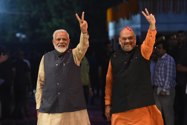 Indian Prime Minister Narendra Modi (L) and president of the ruling Bharatiya Janata Party (BJP) Amit Shah gesture as they celebrate the victory in India's general elections, in New Delhi on May 23, 2019. Hindu nationalist Prime Minister Narendra Modi claimed victory on May 23 in India's general election and vowed an "inclusive" future, with his party headed for a landslide win to crush the Gandhi dynasty's comeback hopes.[Photo: AFP/Money SHARMA]