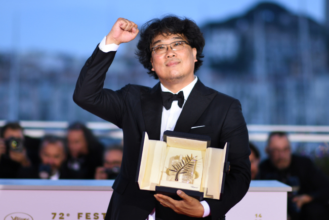 South Korean director Bong Joon-Ho celebrates on stage after he won the Palme d'Or for the film "Parasite (Gisaengchung)" on May 25, 2019 during the closing ceremony of the 72nd edition of the Cannes Film Festival in Cannes, southern France. [Photo: AFP]