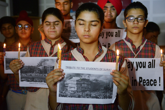 Indian students hold candles as they pay tribute to the students died in a fire in a building in India housing a college in Surat, at a school in Amritsar on May 25, 2019. [Photo: AFP]