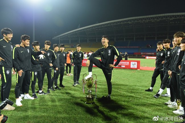 A member of the South Korean team steps on the trophy as other members of the team gather around him after they won this year's Panda Cup International Youth Football Tournament in Chengdu, Sichuan Province. [Photo: Weibo]