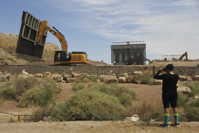 A local takes a picture at workers building a border fence in a private property located in the limits of the US States of Texas and New Mexico taken from Ciudad Juarez, Chihuahua state, Mexico on May 26, 2019. [Photo: AFP]