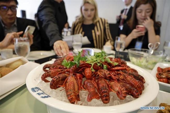 People eat crayfish during the Qianjiang crayfish tasting party at the United Nations headquarters in New York, June 4, 2019. [Photo: Xinhua]