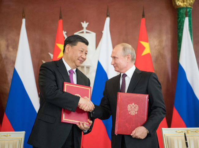 Chinese President Xi Jinping (L) and his Russian counterpart Vladimir Putin sign the statements on elevating bilateral ties to the comprehensive strategic partnership of coordination for a new era and on strengthening contemporary global strategic stability, and witness the signing of a number of cooperation documents, after their talks in Moscow on June 5, 2019. [Photo: Xinhua]