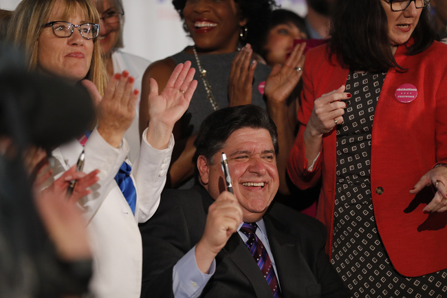 Illinois Gov. J.B. Pritzker signs the Reproductive Health Act into law with bill sponsors Illinois State Senator Melinda Bush, left, and Illinois State Rep. Kelly Cassidy, right, at the Chicago Cultural Center on Wednesday, June 12, 2019. The law establishes "the fundamental right" of a pregnant woman to have an abortion and states that "a fertilized egg, embryo, or fetus does not have independent rights." [Photo: IC/Chicago Tribune/Jose M. Osorio]