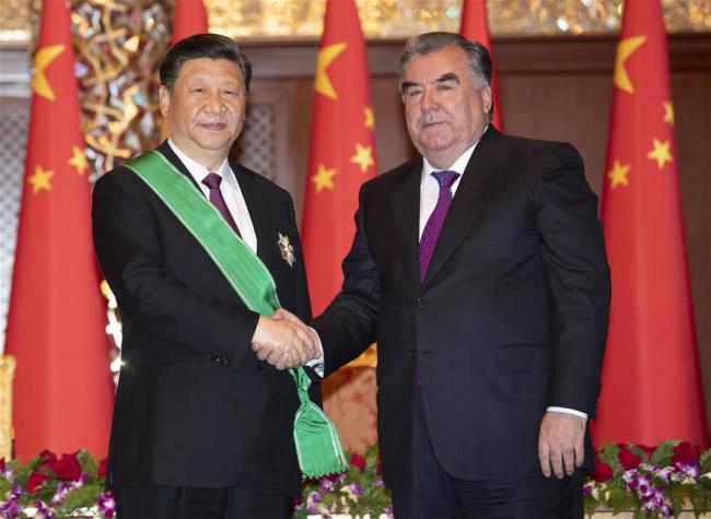 Chinese President Xi Jinping (L) receives the Order of the Crown, Tajikistan's highest decoration, from Tajik President Emomali Rahmon during a ceremony in Dushanbe, Tajikistan, June 15, 2019. [Photo: Xinhua]
