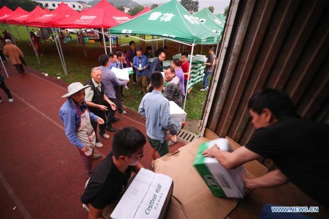 People distribute relief materials at Shuanghe Town High School in Changning County of Yibin City, southwest China's Sichuan Province, June 18, 2019. [Photo: Xinhua]