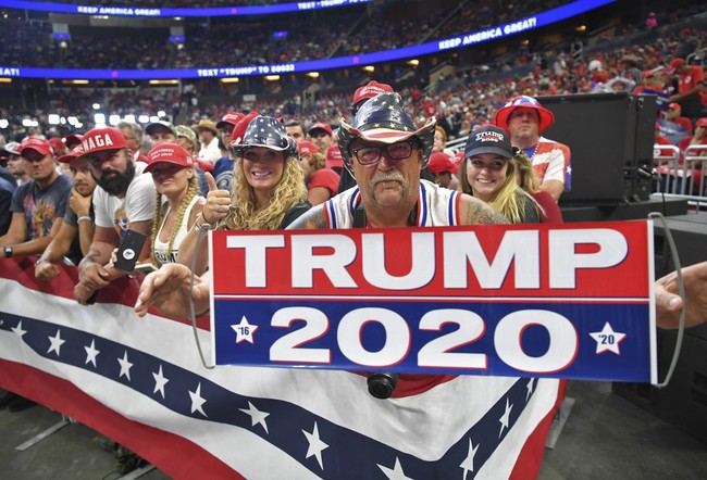 A man holds up a sign as the crowd waits for US President Donald Trump to arrive at a rally at the Amway Center in Orlando, Florida to officially launch his 2020 campaign on June 18, 2019. [Photo: AFP]