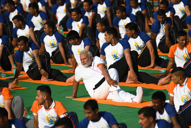 Indian Prime Minister Narendra Modi (C) participates in a mass yoga session along with other practitioners to mark International Yoga Day at the Forest Research Institute (FRI) in Dehradun on June 21, 2018. [File Photo: AFP/Prakash Singh]