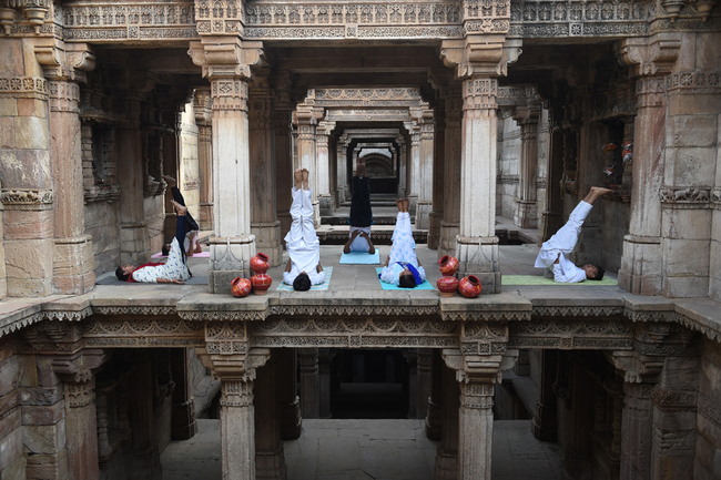 Indian yoga practitioners take part in a yoga session on International Yoga Day at the 15th century Adalaj Stepwell in Adalaj, some 40km from Ahmedabad in western Gujarat state, on June 21, 2019. [Photo: AFP/Sam Panthaky]