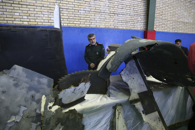 Head of the Revolutionary Guard's aerospace division Gen. Amir Ali Hajizadeh looks at debris from what the division describes as the U.S. drone which was shot down on Thursday, in Tehran, Iran, Friday, June 21, 2019. [Photo: AP]