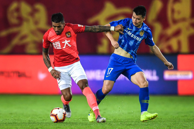 Brazilian football player Paulinho, left, of Guangzhou Evergrande dribbles against Luo Jing of Jiangsu Suning in their 9th round match during the 2019 Chinese Football Association Super League (CSL) in Guangzhou, Guangdong on May 12, 2019. [Photo: IC]
