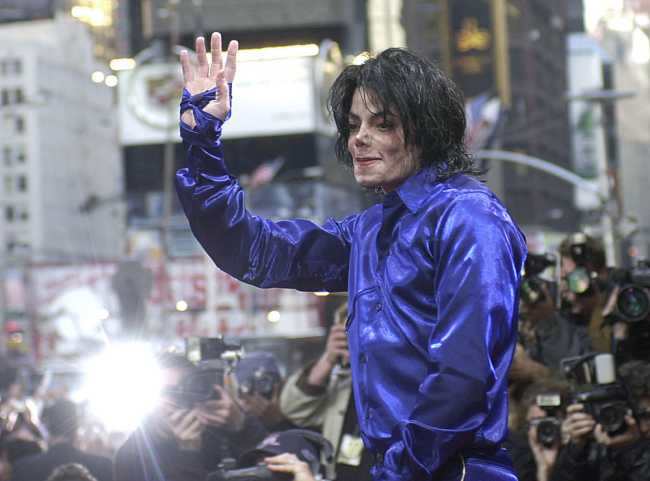 Michael Jackson waves to crowds gathered to see him at his first ever in-store appearance, New York, November 7, 2001. [Photo: IC]