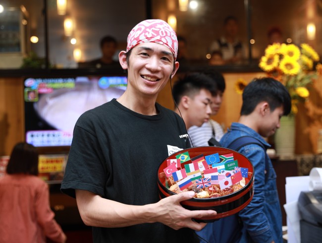 Chef Masafumi Takeda showing off 20 octopus balls--a classic Osaka snack--bearing the national flags of the G20 members, June 26, 2019, in Chuo Ward, Osaka Prefecture, Japan. The G20 summit meeting will be held in Osaka on June 28-29, 2019. [Photo: China Plus]