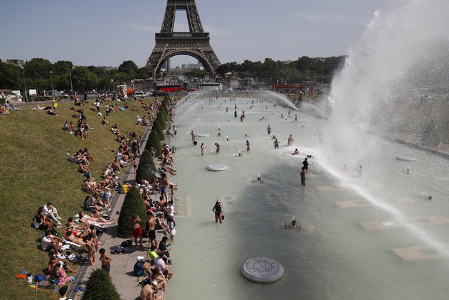 People bathe in the Trocadero Fountain near the Eiffel Tower in Paris during a heatwave on June 28, 2019. [Photo: AFP/Zakaria Abdelkafi]