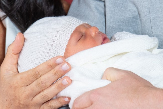 Britain's Prince Harry, Duke of Sussex (R), and his wife Meghan, Duchess of Sussex, pose for a photo with their newborn baby son, Archie Harrison Mountbatten-Windsor, in St George's Hall at Windsor Castle in Windsor, west of London on May 8, 2019. [Photo: AFP/Dominic Lipinski]