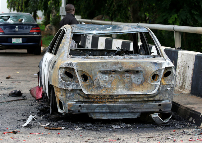 A man stands near a burnt vehicle outside the National Assembly, after clashes between police and a group of Shi'ite Muslim protesters in Abuja, Nigeria July 9, 2019. [Photo: VCG]