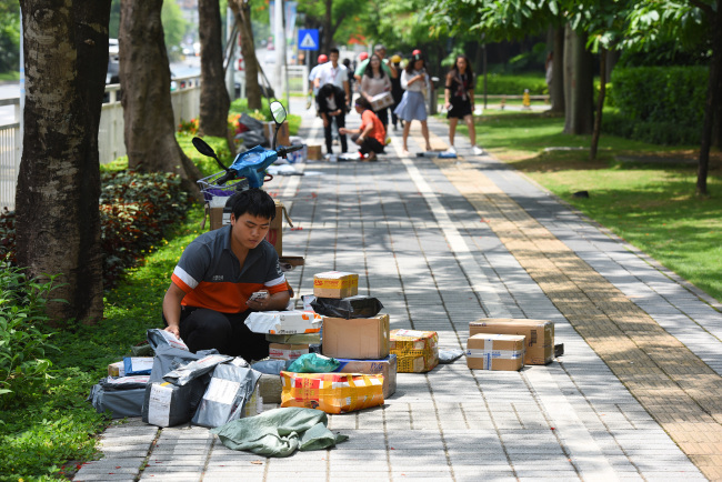 An express delivery man is sorting packages, in Shenzhen, on May 23, 2015. [File Photo: VCG]
