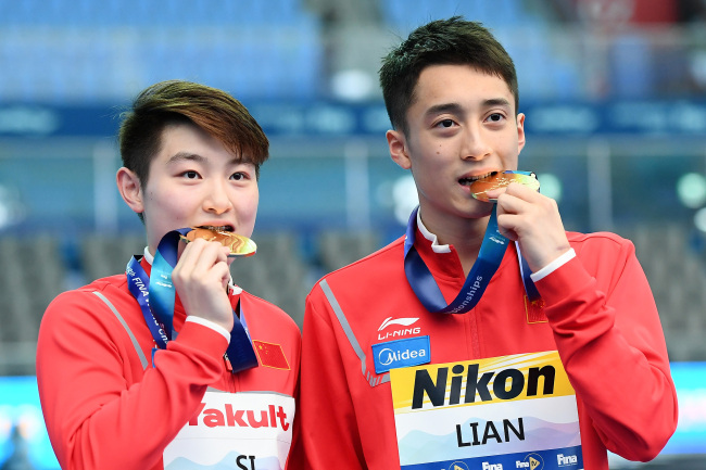 Gold medalists Yajie Si and Junjie Lian of China pose during the medal ceremony for the Mixed 10m Synchro Platform Final on day two of the Gwangju 2019 FINA World Championships at Nambu International Aquatics Centre on July 13, 2019 in Gwangju, South Korea. [Photo: VCG/Getty Images/Quinn Rooney]
