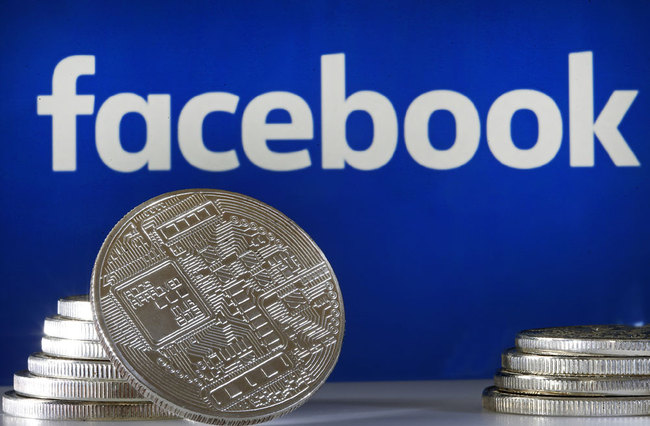 In this photo illustration, a visual representation of a digital cryptocurrency coin sits on display in front of a Facebook logo on June 17, 2019 in Paris, France. [File photo: Chesnot/Getty Images via VCG]