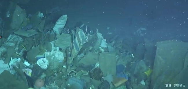 A large patch of garbage discovered by China's Deep Sea Warrior submarine about 2,000 meters underwater. [Screenshot: China Plus] 