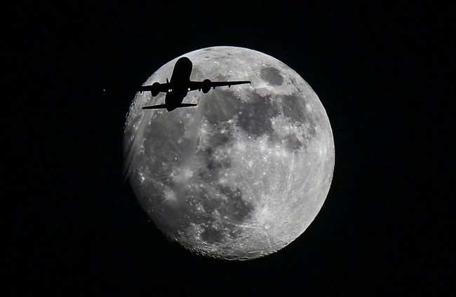 An passenger airplane of Mesa Airlines ASH5630 approaching Los Angeles International Airport flies past the moon in Los Angeles, California, on November 23, 2015. [File Photo: IC]