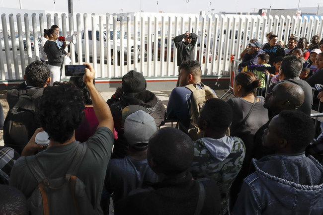 A woman addresses migrants as they wait to apply for asylum in the United States along the border Tuesday, July 16, 2019, in Tijuana, Mexico. [Photo: IC]