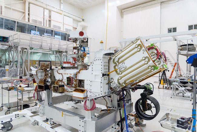 The electricity for NASA's Mars 2020 rover is provided by a power system called a Multi-Mission Radioisotope Thermoelectric Generator, or MMRTG. The MMRTG will be inserted into the aft end of the rover between the panels with gold tubing visible at the rear, which are called heat exchangers. [Photo: NASA/JPL-Caltech]