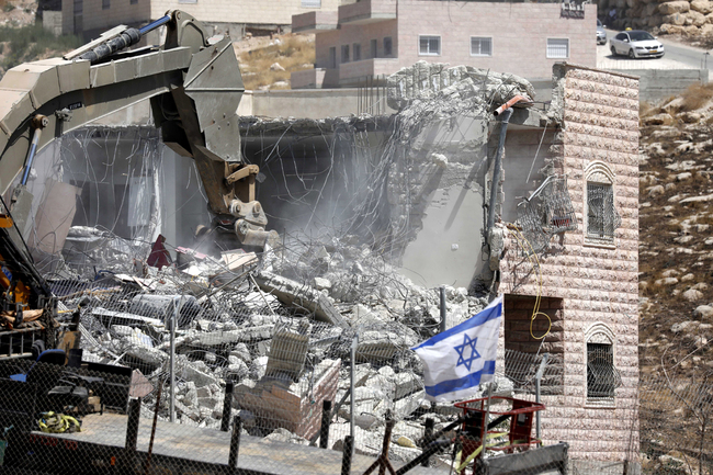 An Israeli army excavator machine demolishes a building in the Palestinian village of Sur Baher, in East Jerusalem, July 22, 2019. [Photo: IC]