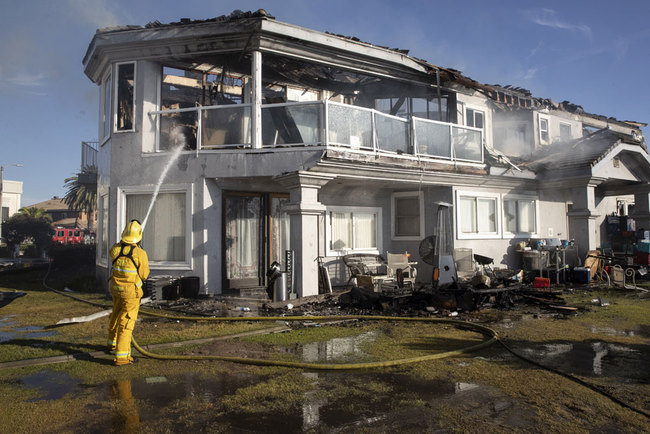 Firefighters put out a brush fire that spread to houses in Chino Hills, East of Los Angeles, California, USA, on July 28, 2019. [Photo: EPA via IC/Etienne Laurent]