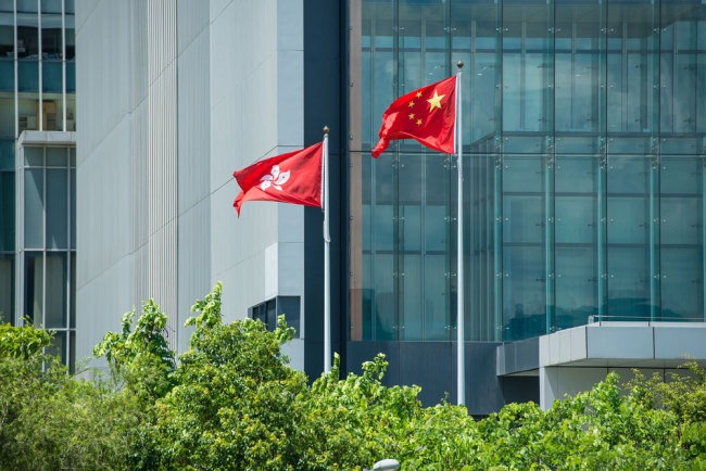 The national flag of China and the regional flag of the Hong Kong Special Administrative Region flutter in Hong Kong. [File photo: VCG]