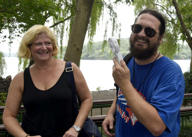 A foreign visitor uses a mini-fan in Hangzhou, capital of east China's Zhejiang Province. [File Photo: IC]