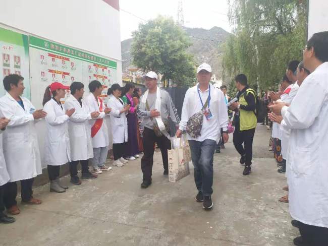 Medical professionals arrived at dispensary of Tuoding Township. Local people were waiting at the gate to welcome them. [Photo: China Plus]