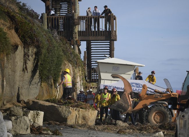 Search and rescue personnel work at the site of a cliff collapse at a popular beach Friday, Aug. 2, 2019, in Encinitas, Calif. At least one person was reportedly killed, and multiple people were injured, when an oceanfront bluff collapsed Friday at Grandview Beach in the Leucadia area of Encinitas, authorities said. [Photo: AP/Denis Poroy]