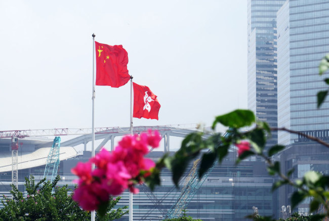The Chinese national flag and the flag of the Hong Kong Special Administrative Region flutter in Hong Kong. [File photo: IC]