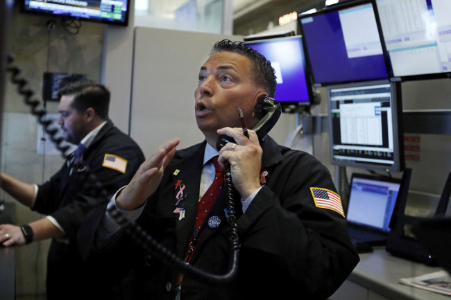 File photo shows trader Jonathan Mueller working on the floor of the New York Stock Exchange. [Photo: IC]
