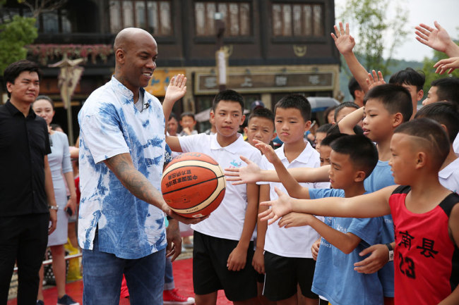 Former NBA player Stephon Marbury interacts with children in Danzhai County, Guizhou Province on August 2, 2019. [File photo: VCG]