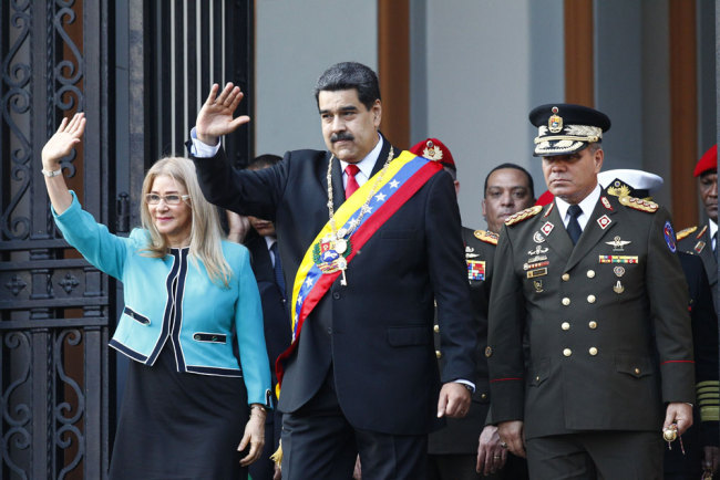 Venezuela's President Nicolas Maduro, center, and first lady Cilia Flores, wave to supporters as they leave the National Pantheon after attending a ceremony to commemorate an 1800's independence battle, in Caracas, Venezuela, Wednesday, Aug. 7, 2019. [File photo: AP/Leonardo Fernandez]