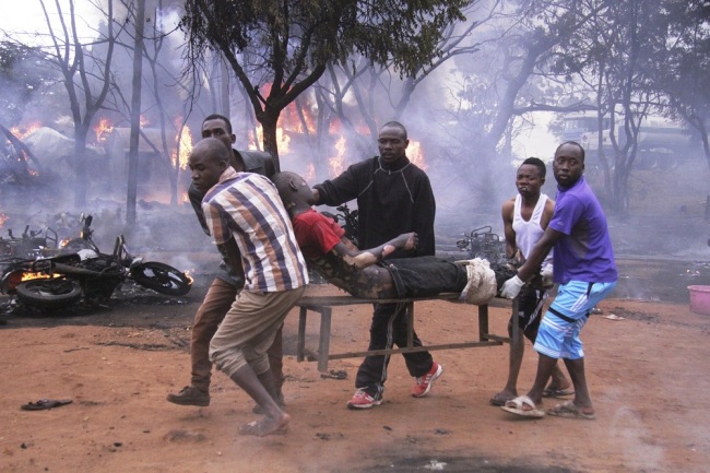 An injured man is carried from the scene as a patrol tanker burns in the background, Saturday, August 10, 2019, in Morogoro, Tanzania. [Photo: AP via IC]