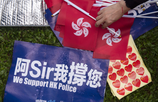 A placard and Hong Kong regional flags seen during the rally in support of the police in Hong Kong. [File Photo: IC]