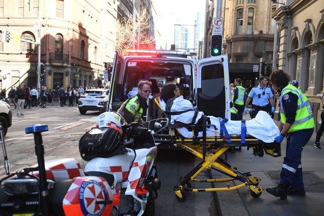 A woman is taken to an ambulance by paramedics in Sydney, Australia, August 13, 2019. [Photo: EPA via IC/Dean Lewins]