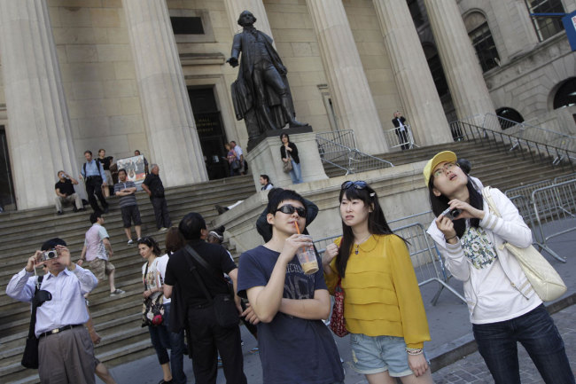 In this Friday, June 15, 2012, file photo, a group of tourists from China take in the sights of the New York Stock Exchange and Federal Hall National Memorial. [Photo: IC]
