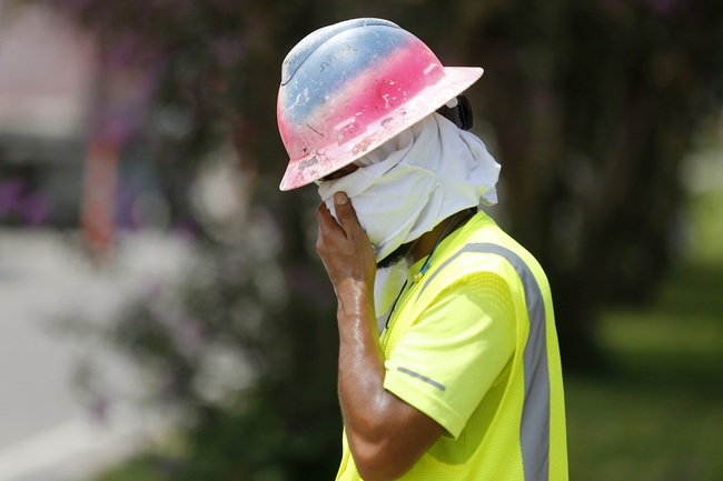 Construction worker Dineose Vargas wipes his face at a construction site on the Duncan Canal in Kenner, La., Tuesday, Aug. 13, 2019. [Photo: AP/Gerald Herbert]