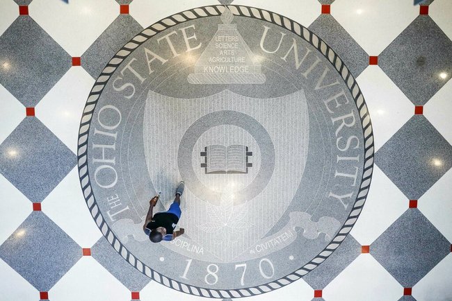 In this May 18, 2019 file photo, pedestrians pass through Ohio State University's student union in Columbus, Ohio. Ohio State University wants to trademark the word “The” when used as part of the school’s name on university merchandise. The school submitted a trademark application this month to the U.S. Patent and Trademark Office. The application requests a standard character trademark for the title “The Ohio State University” that would cover various items including T-shirts, baseball caps and hats. [Photo: AP Photo/John Minchillo]