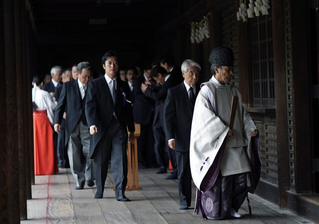 Japanese lawmakers are escorted by a Shinto priest after they prayed for war dead at the controversial Yasukuni Shrine in Tokyo, Japan, 15 August 2019, the day of the 74th anniversary of the end of World War II. Some 3.1 million Japanese soldiers and civilians were killed during the war, almost 2.5 million of whom are enshrined at Yasukuni, including convicted WWII war criminals. [EPA/FRANCK ROBICHON via IC]