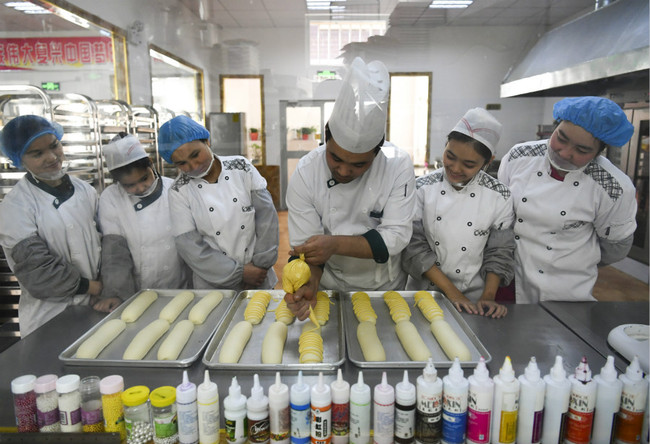 People in Xinjiang learn how to make bread at a training center in the city of Urumqi in Xinjiang on April 13, 2018. [File photo: China News Service via VCG/Liu Xin]