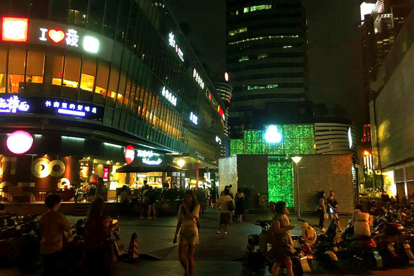 People walk outside a street in Shanghai at night. [Photo: Imagine China]