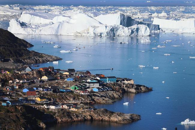 The village of Ilulissat is seen near the icebergs that broke off from the Jakobshavn Glacier on July 24, 2013 in Ilulissat, Greenland. [File Photo: JONATHAN NACKSTRAND/AFP via VCG]