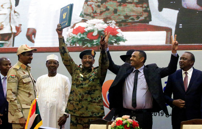Sudan's Head of Transitional Military Council, Lieutenant General Abdel Fattah Al-Burhan, and Sudan's opposition alliance coalition's leader Ahmad al-Rabiah, celebrate the signing of the power sharing deal, that paves the way for a transitional government, and eventual elections in Khartoum, Sudan, August 17, 2019. [File photo: Reuters/Mohamed Nureldin Abdallah]