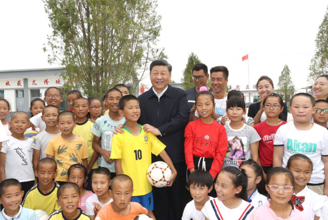 Xi Jinping, general secretary of the Communist Party of China Central Committee, poses for photos with students at a primary school in Gulang County, Gansu Province on Wednesday, August 21, 2019. [Photo: Xinhua]